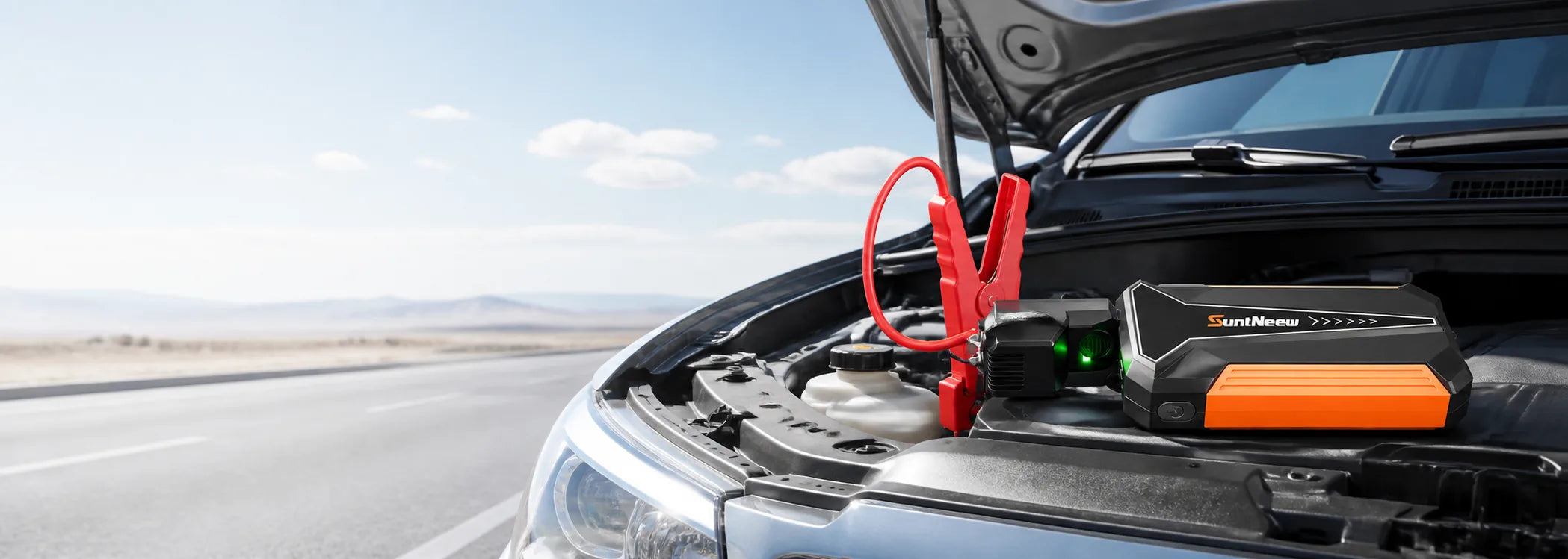 SuntNeew jump starter connected in a vehicle engine bay